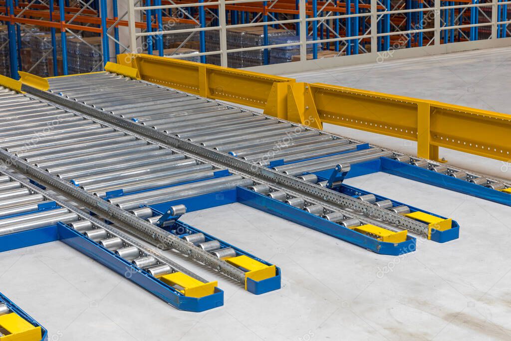 Regały przepływowe z rolkami w magazynie
